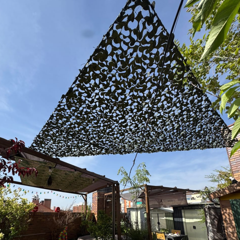 Filet de camouflage triangulaire sombre sur une pergola de jardin